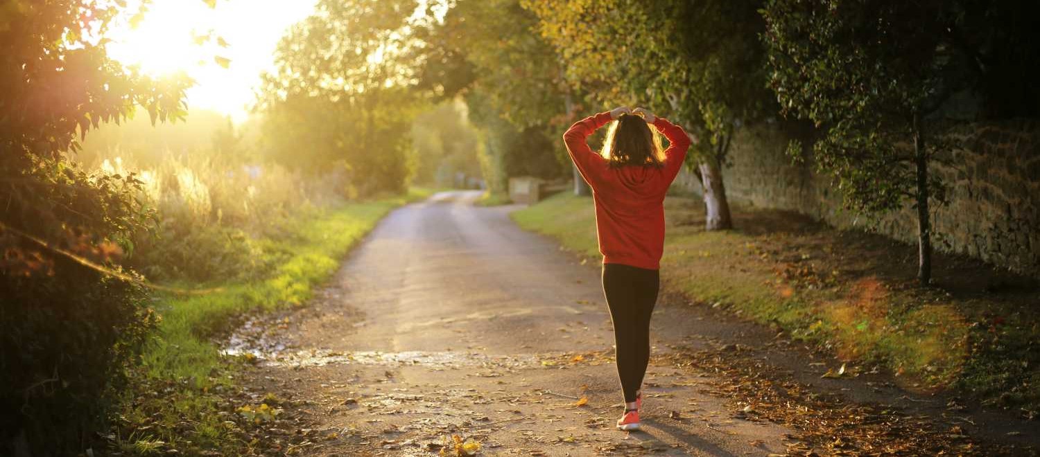 fitness vrouw wandelend in bos zon