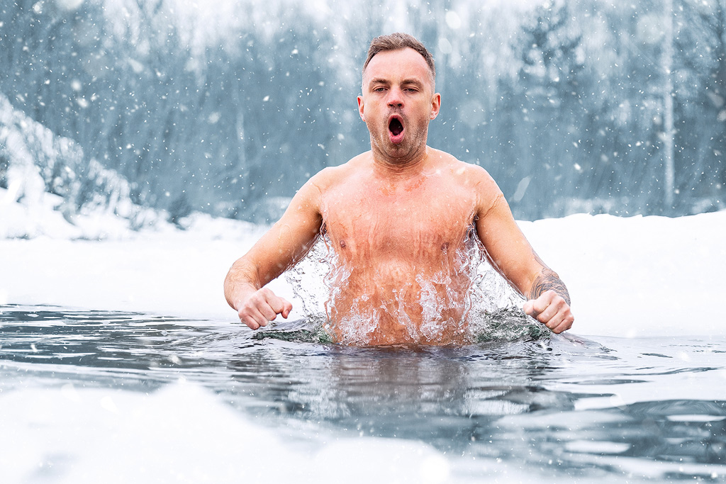 Man neemt een duik in natuurijs in de winter.